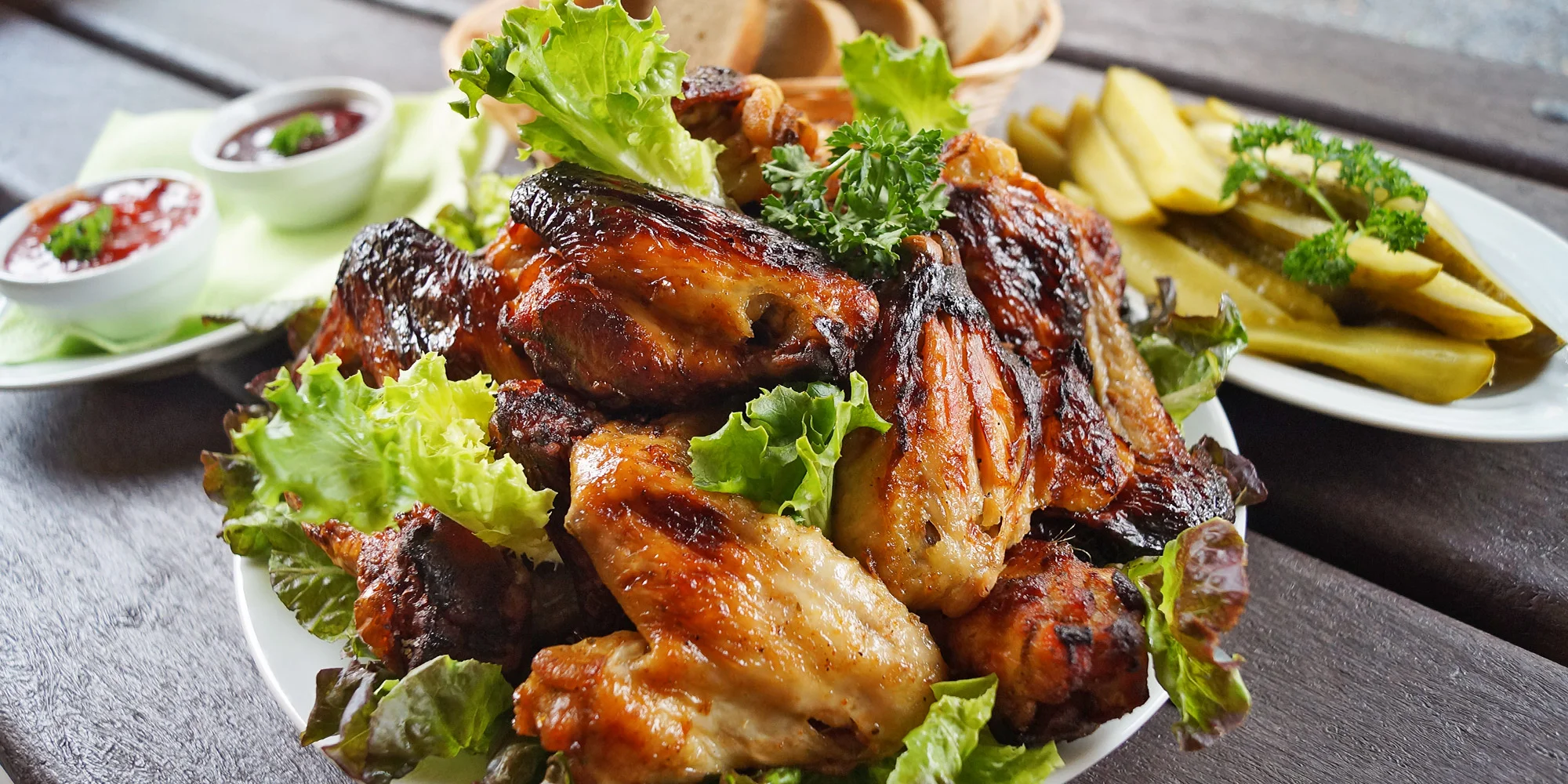 1,5 kg pečených kuřecích křídel, chleba, zeleninová obloha a omáčky
