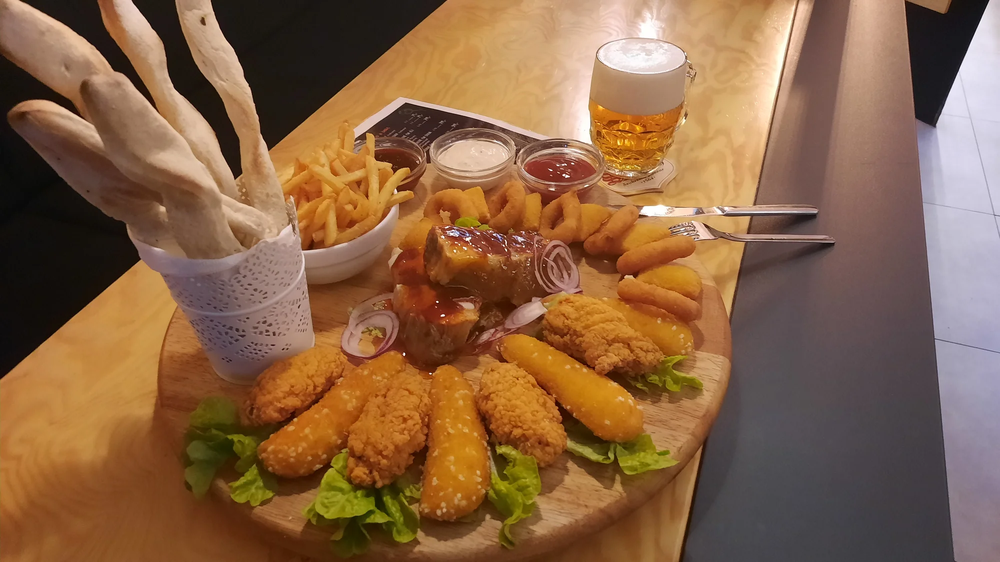 Prkno s masem a sýrem pro 2 až 4 osoby: křídla, stripsy, cibulové kroužky, žebra, hranolky a k tomu i pivo či Kofola