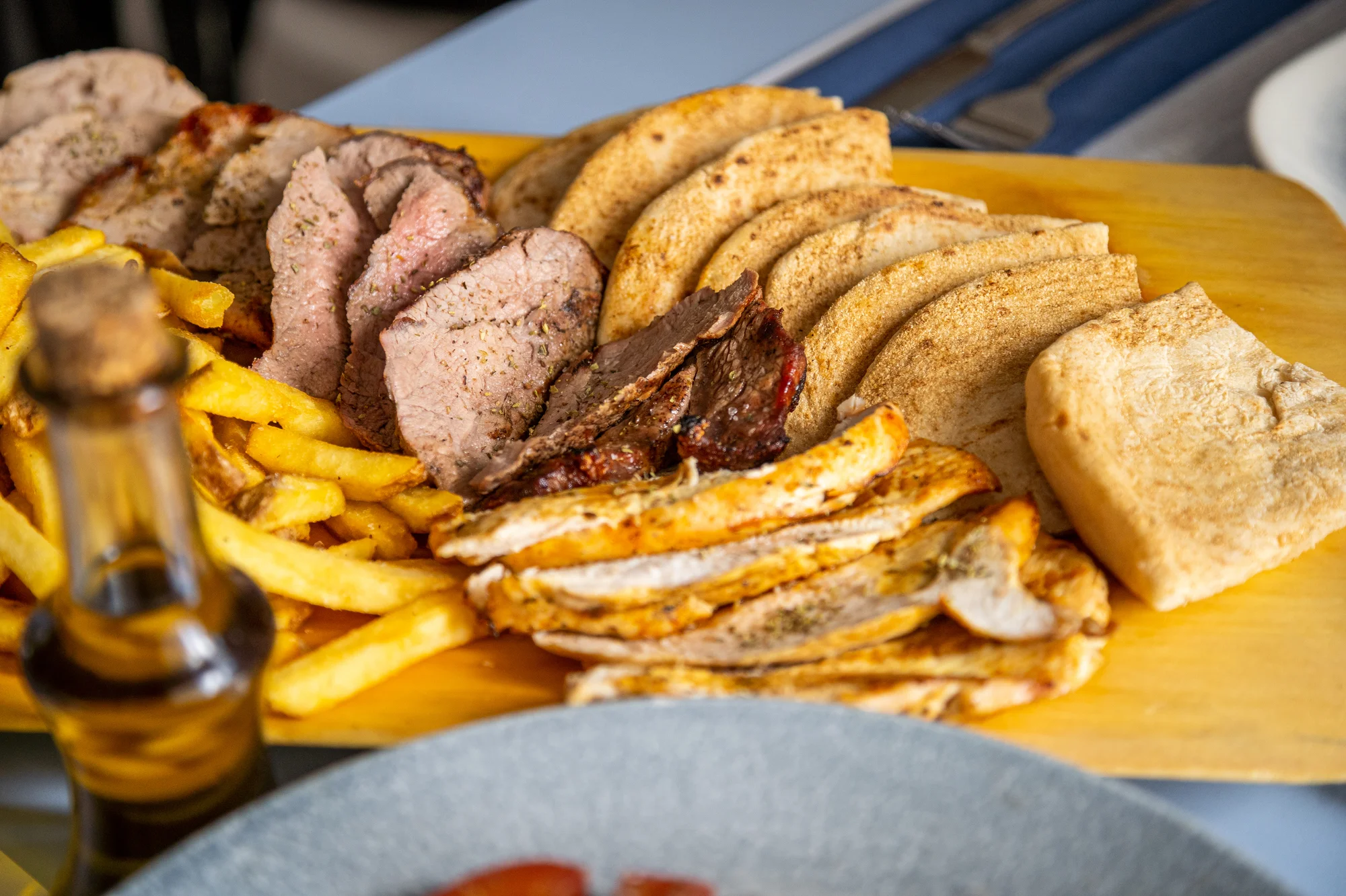 Steakové prkno z grilu v pravé řecké restauraci: rib eye, vepřová panenka i kuře, pita a hranolky
