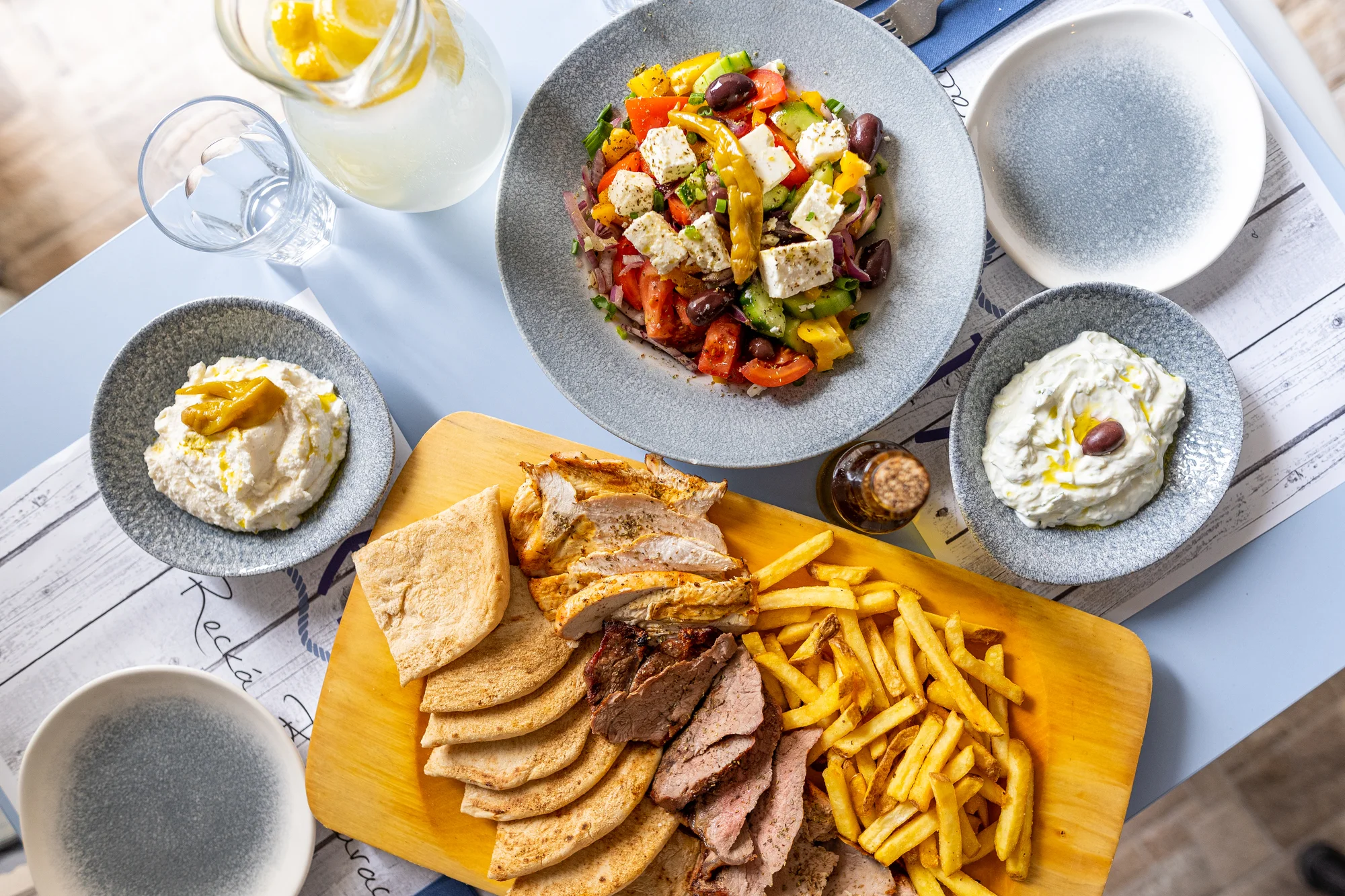Steakové prkno z grilu v pravé řecké restauraci: rib eye, vepřová panenka i kuře, pita a hranolky