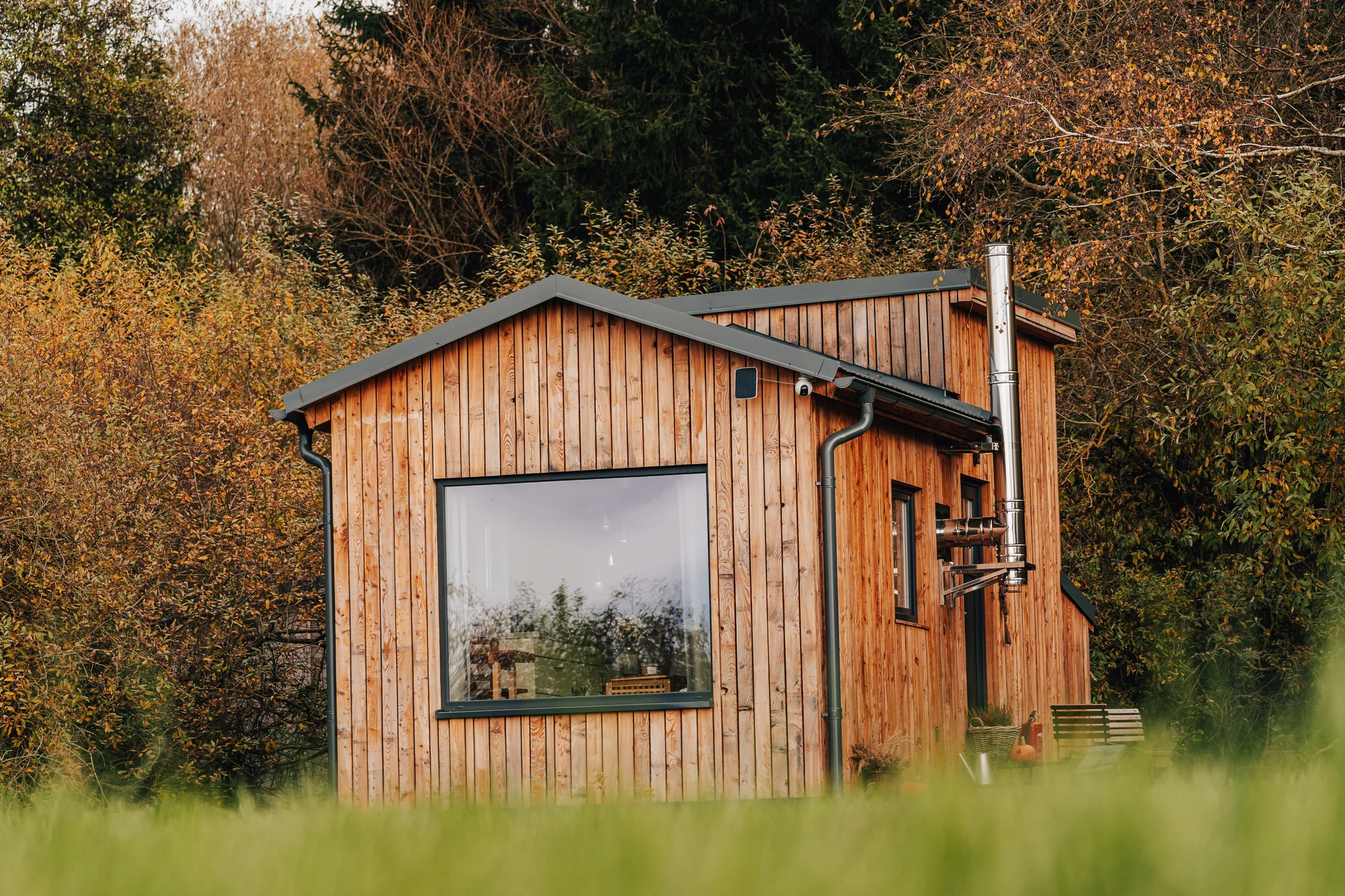 Vybavený tiny house uprostřed přírody s venkovním posezením