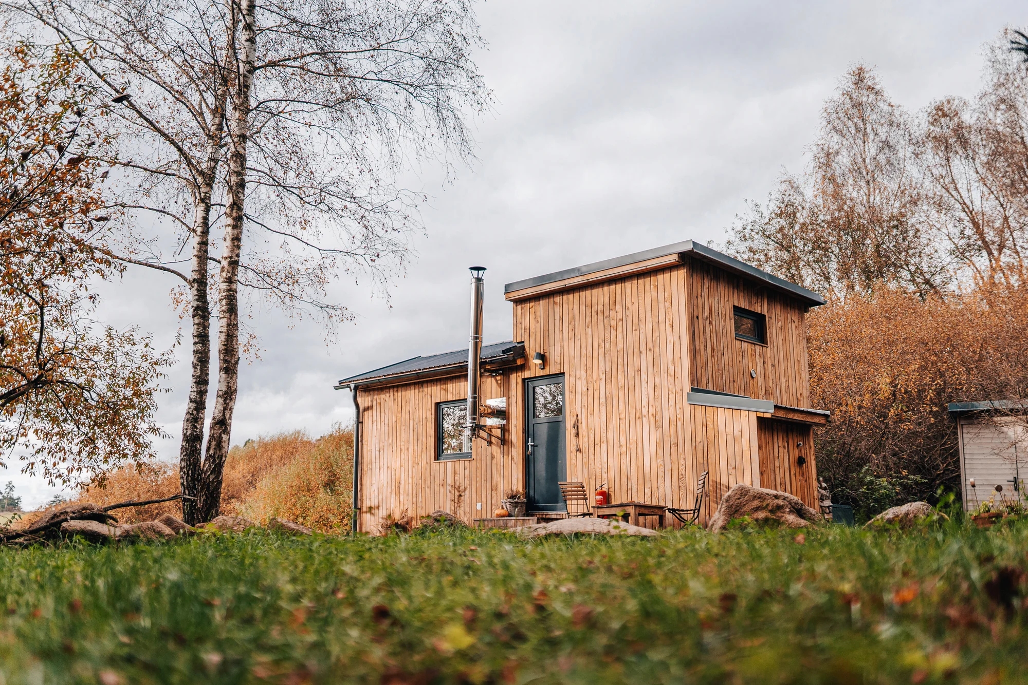 Vybavený tiny house uprostřed přírody s venkovním posezením