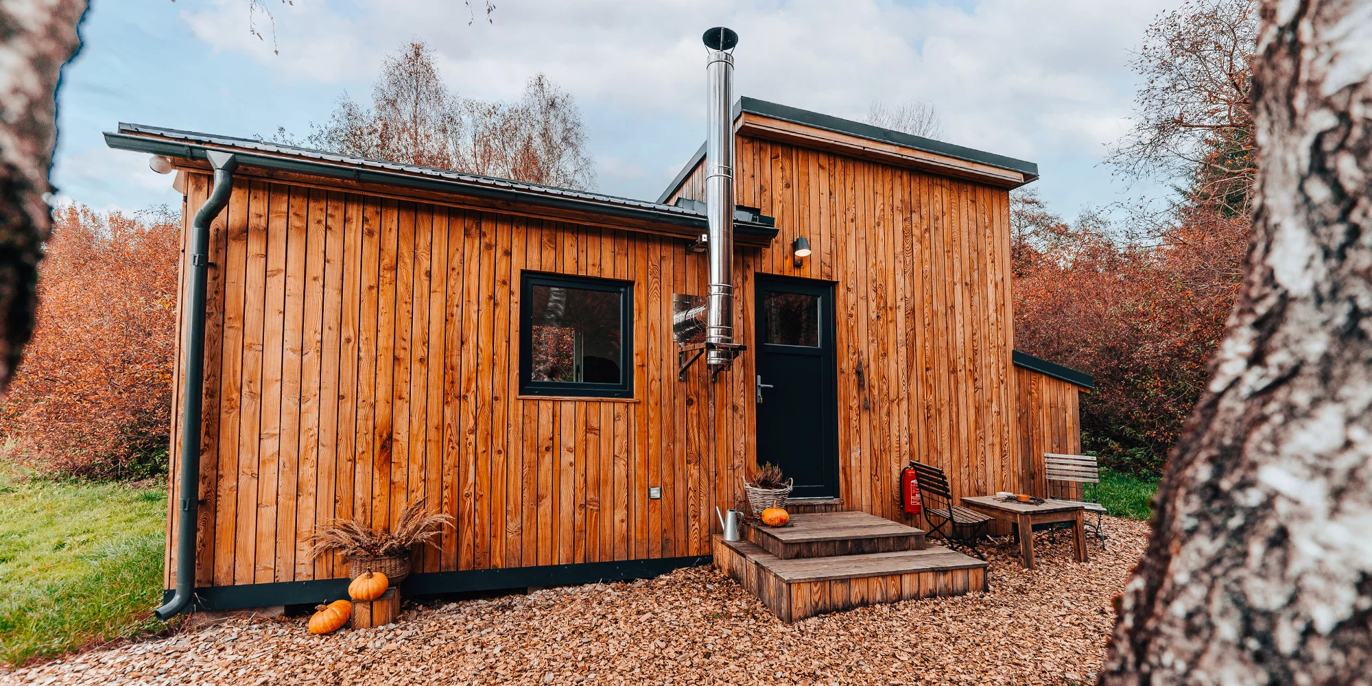 Vybavený tiny house uprostřed přírody s venkovním posezením