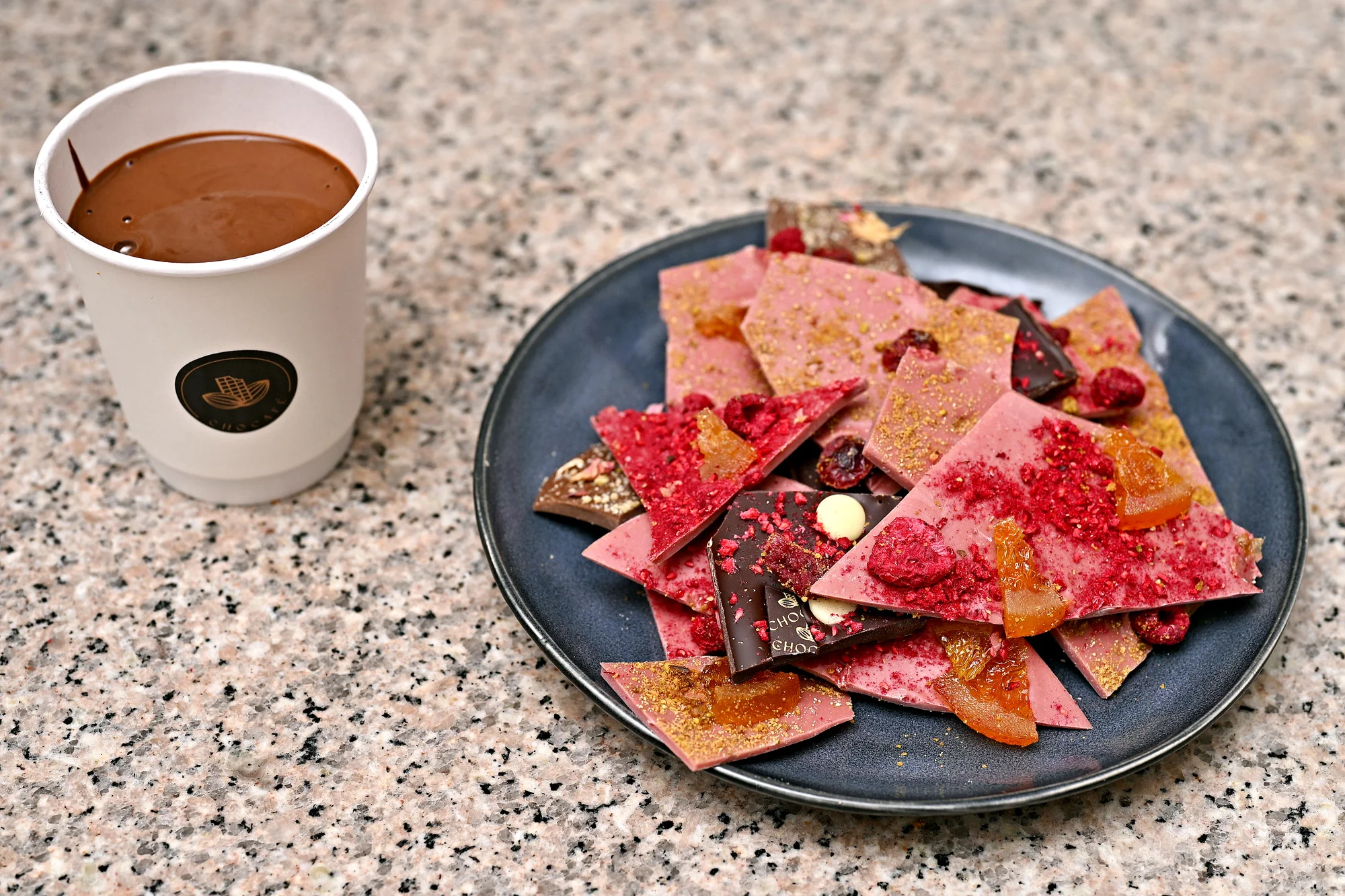 Ručně vyrobená lámaná belgická čokoláda Callebaut v papírové krabičce z Chocafé a horký nápoj k tomu