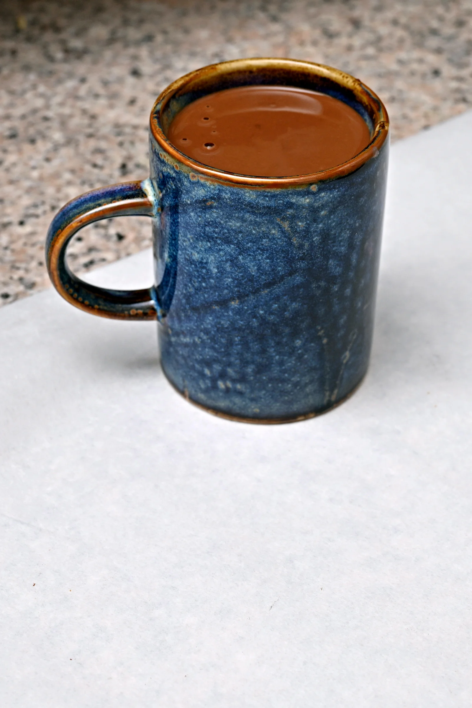 Ručně vyrobená lámaná belgická čokoláda Callebaut v papírové krabičce z Chocafé a horký nápoj k tomu