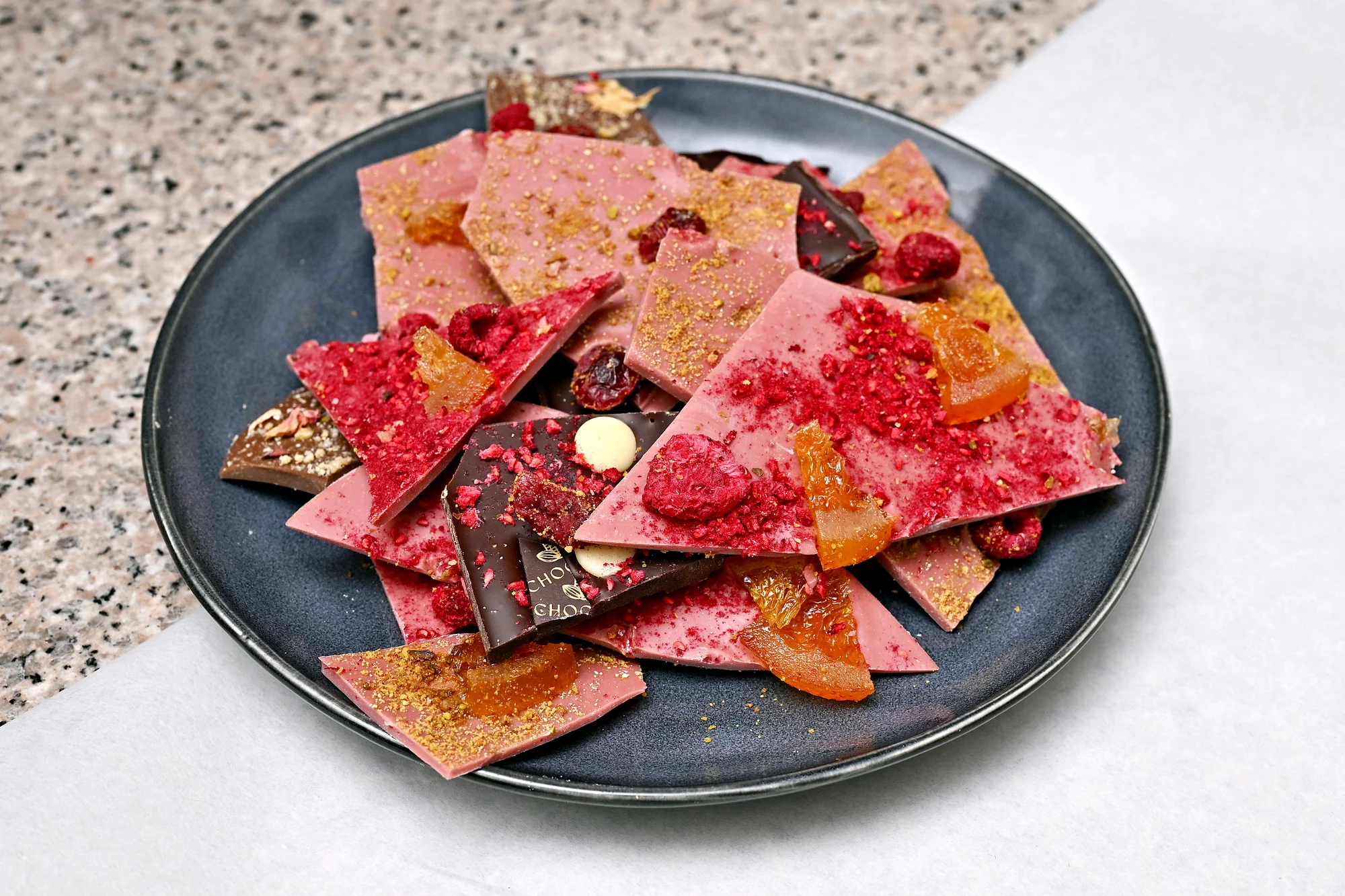 Ručně vyrobená lámaná belgická čokoláda Callebaut v papírové krabičce z Chocafé a horký nápoj k tomu