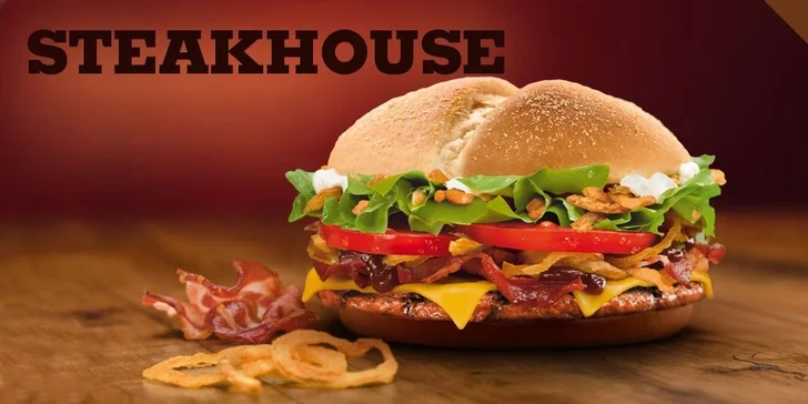 Steakhouse burger, to je šťavnaté grilované hovězí maso v kukuřičné bulce, se slaninou, opečenou cibulkou, ledovým salátem, rajčetem, sýrem, krémovou majonézou a omáčkou BBQ.