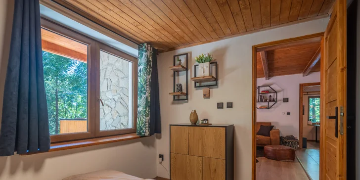 Interiér je stylově zařízený dřevem a světlými barvami.