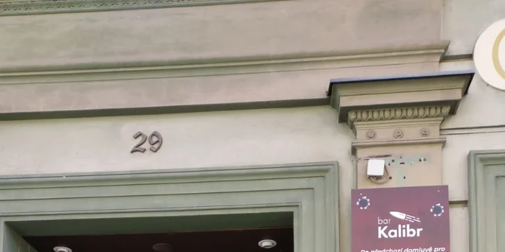 Vstup přes dveře na fotce, nalevo od venkovního poutače (ne přes prodejnu zbraní, to je jiná provozovna, kterou se na střelnici nedostanete).