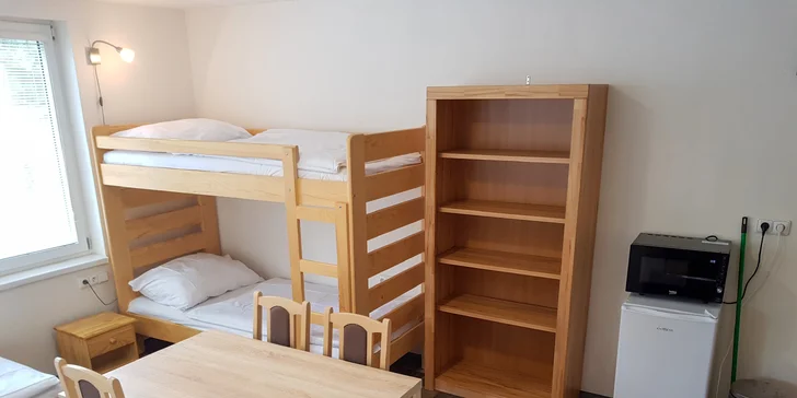  Ve zděné chatce nechybí jídelní stůl s židlemi.