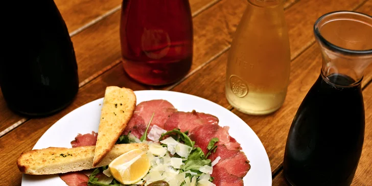 Karafa vína, bramborové lupínky a carpaccio s výhledem na Karlův most