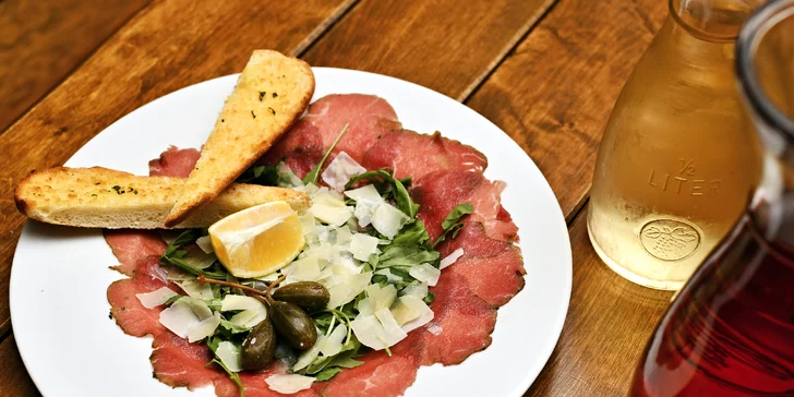 Karafa vína, bramborové lupínky a carpaccio s výhledem na Karlův most