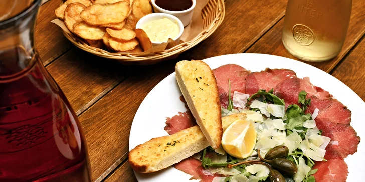 Karafa vína, bramborové lupínky a carpaccio s výhledem na Karlův most