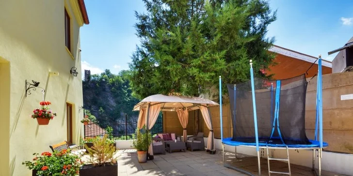 Hotelový dvorek je uzavřený, aby děti nevběhly na ulici. Řádit tu mohou na trampolíně i skluzavce.