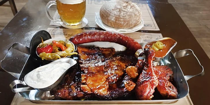 Pekáč plný 1 kg grilovaných dobrot pro 2 osoby: žebra, stehýnka, klobása, zelenina, dip i chleba
