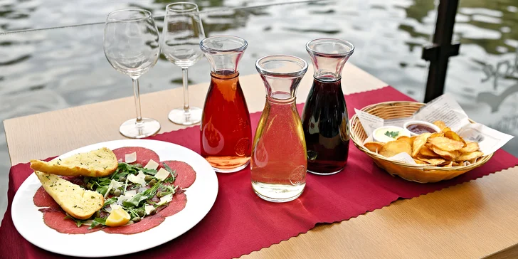 Karafa vína, bramborové lupínky a carpaccio s výhledem na Karlův most