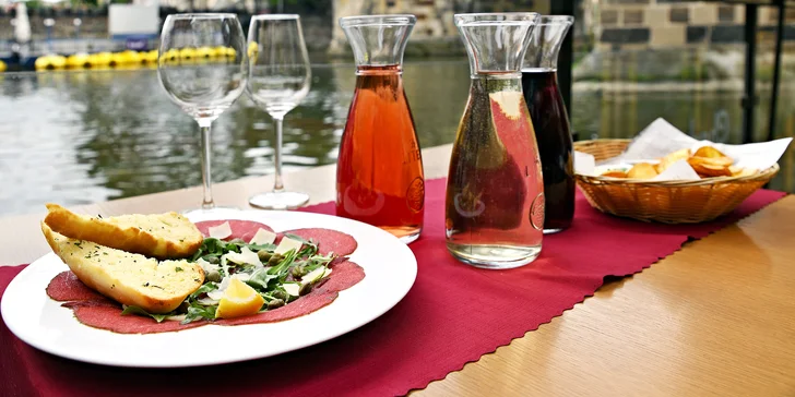 Karafa vína, bramborové lupínky a carpaccio s výhledem na Karlův most