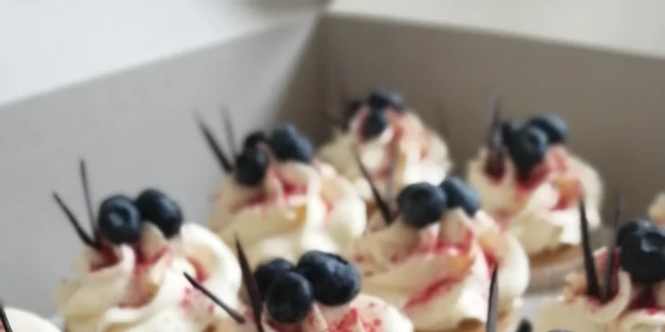 Výběr ze 2 druhů cupcakes: vanilkový s borůvkami a makový s ostružinami