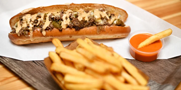 Bohatě obložené bagety s plátky bifteku a roztaveným sýrem i menu s hranolky a omáčkou
