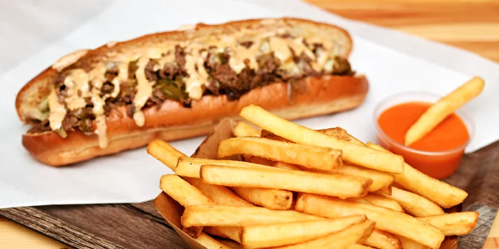 Bohatě obložené bagety s plátky bifteku a roztaveným sýrem i menu s hranolky a omáčkou