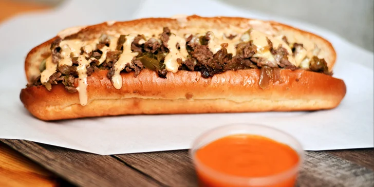 Bohatě obložené bagety s plátky bifteku a roztaveným sýrem i menu s hranolky a omáčkou