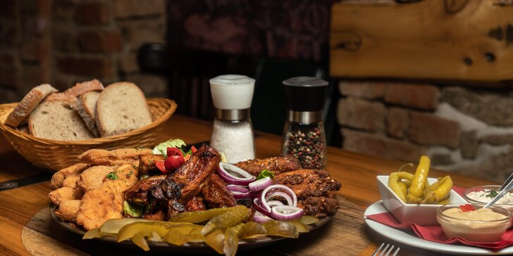 Talíř plný masa ve stylové restauraci: kuřecí křídla, vepřová žebra i smažené řízky