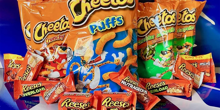Balíčky amerických dobrot: kukuřičné křupky Cheetos a tyčinky Reese's v různých příchutích
