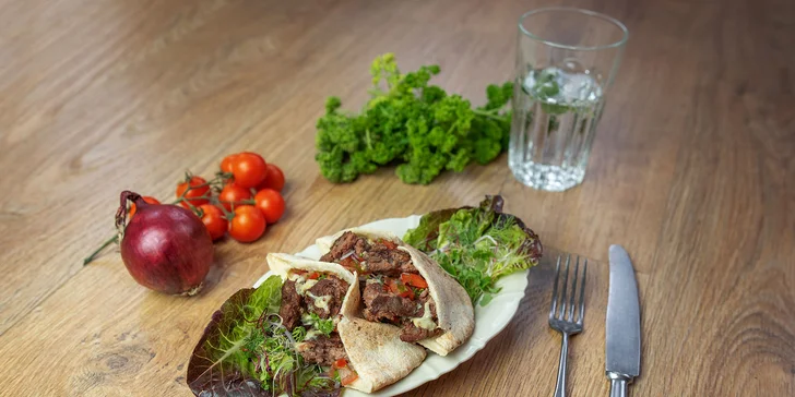 Pita chléb s hovězím burgerem sous-vide se salátkem z rajčat, červené cibule a petrželky.