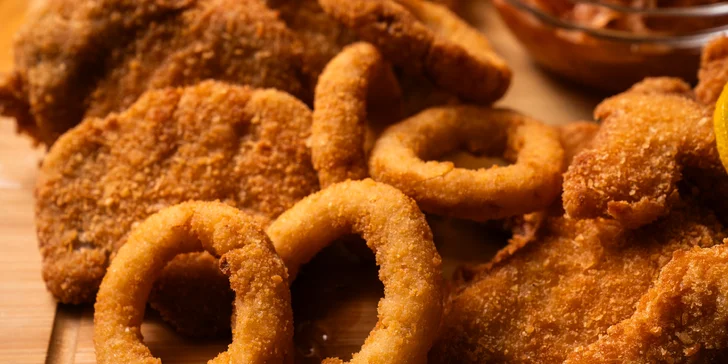 Prkno plné řízků s cibulovými kroužky a hranolkami ve variantách 600 g anebo 1,2 kg masa