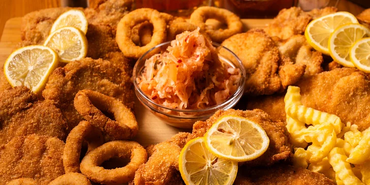 Prkno plné řízků s cibulovými kroužky a hranolkami ve variantách 600 g anebo 1,2 kg masa