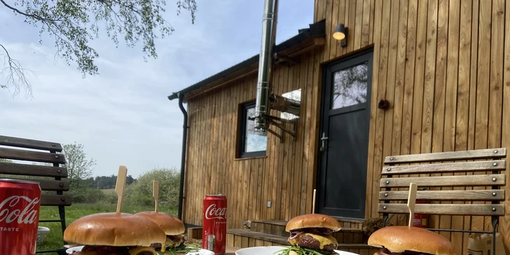 Vybavený tiny house uprostřed přírody s venkovním posezením a grilem