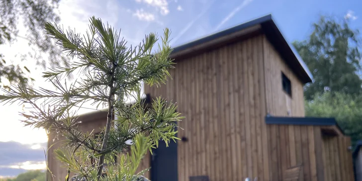 Vybavený tiny house uprostřed přírody s venkovním posezením a grilem