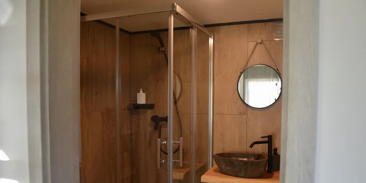 Vybavený tiny house uprostřed přírody s venkovním posezením a grilem