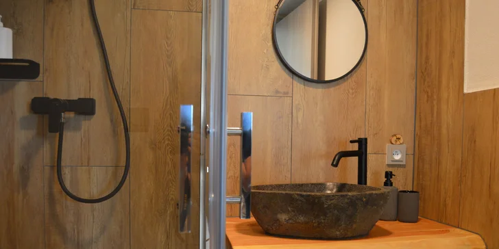 Vybavený tiny house uprostřed přírody s venkovním posezením a grilem