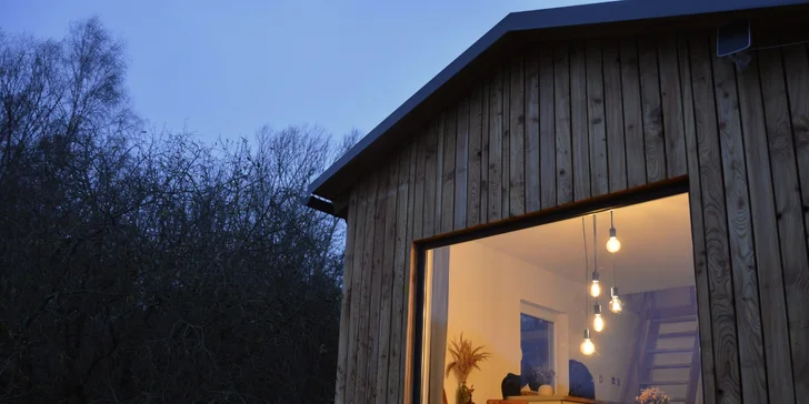Vybavený tiny house uprostřed přírody s venkovním posezením a grilem