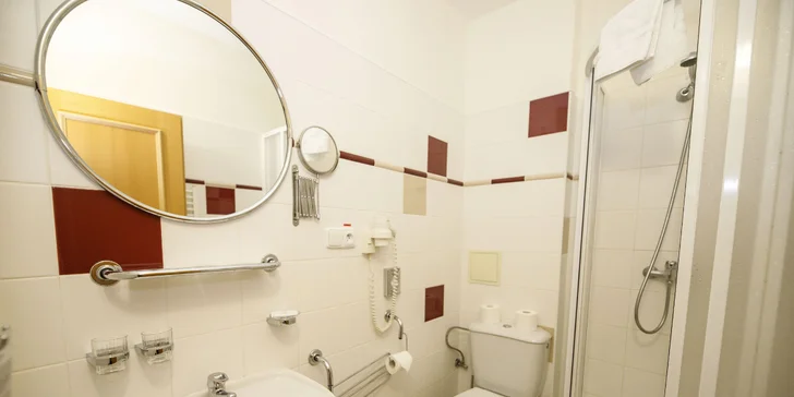 V koupelně pokojů je sprcha, v apartmá pak rohová vana. 