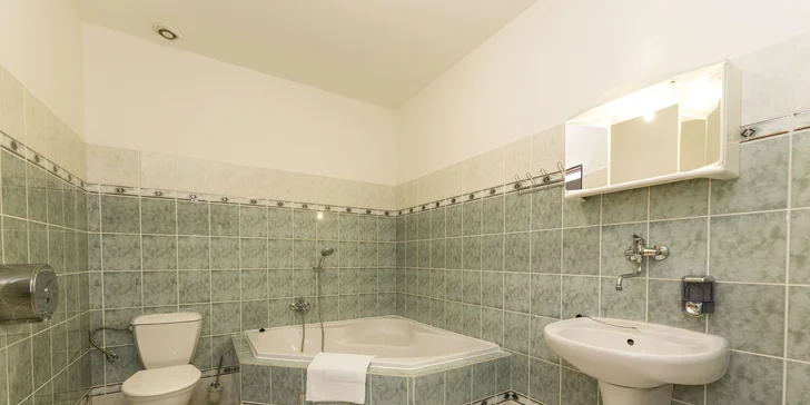 V koupelně apartmánu je rohová vana. 