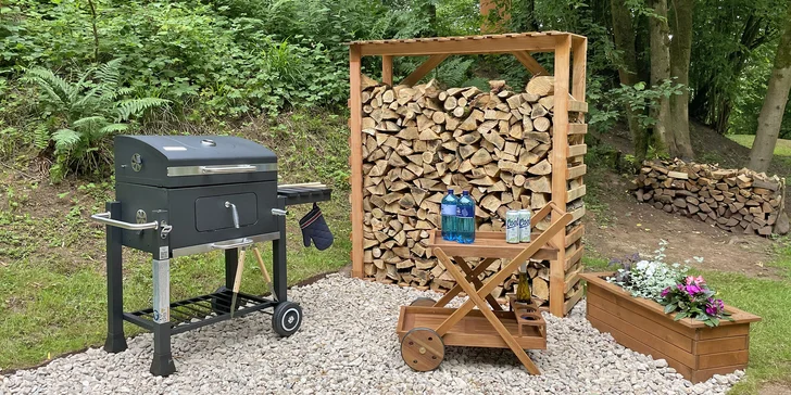 Zázemí pro přípravu dobrot ze zahradního grilu Tarrington House Deluxe na dřevěné uhlí a dřevěný pojízdný stoleček poslouží jako šikovná odkládací plocha na jídlo či nápoje.