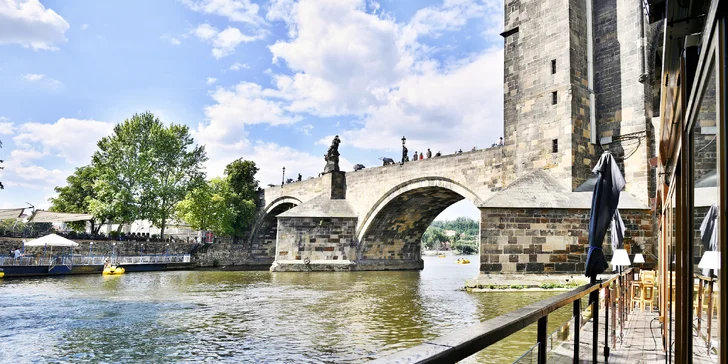 Restauraci najdete v zátoce na plovoucím pontonu a z jejích oken je překrásný výhled na Mosteckou věž i Karlův most.