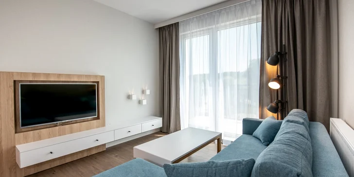 U pokojů nechybí ani obývací pokoj se sedačkou a TV a vlastní balkon.