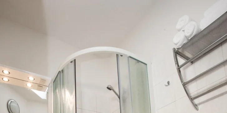 V koupelně je sprcha. 