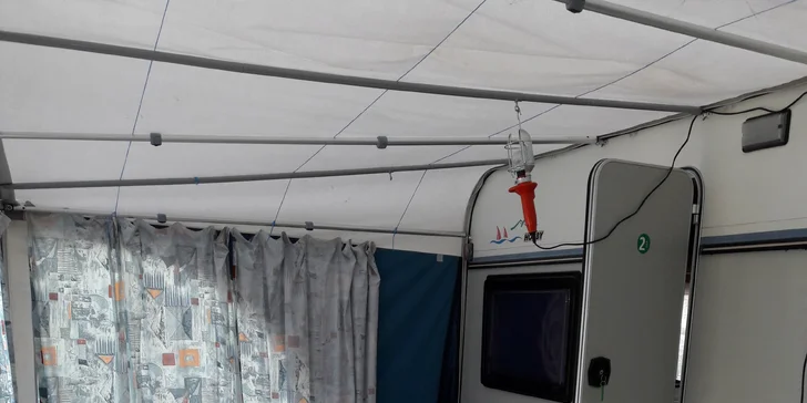 Vařič, základní nádobí, lednice, elektřina, stolek ze židlemi a venkovní předstan – to vše vám zaručí komfort během pobytu.