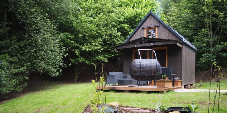 Modřínová terasa nabízí relax ve dvoumístné závěsné houpačce a posezení v ratanovém venkovním nábytku.