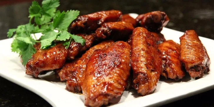 1 kg pikantně pečených kuřecích křidélek s hranolky a omáčkami