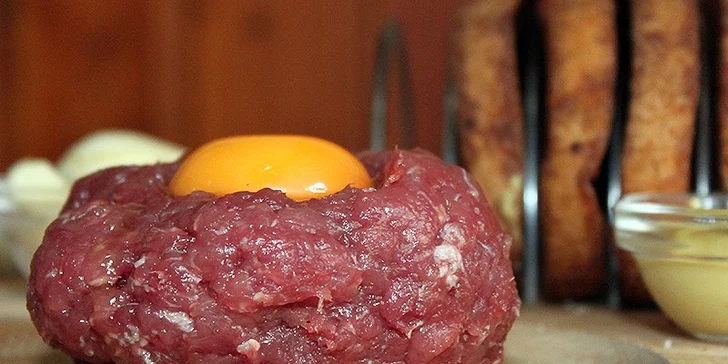 Nemíchaný tatarák s ingrediencemi na dochucení a topinkami