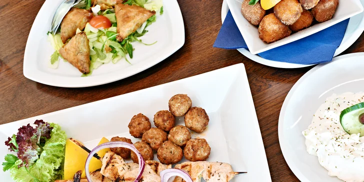 Tradiční řecké menu s předkrmem, mísou plnou masa, tzatziki a dezertem