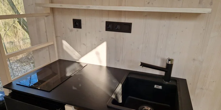 Nechybí kuchyňka s varnou deskou a rychlovarnou konvicí.