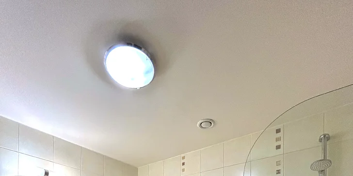 V koupelně čeká vana kombinovaná se sprchou. 