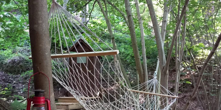 Přímo před chatkou je napnutá houpací síť, kde můžete relaxovat, a najdete tu také posezení a ohniště.