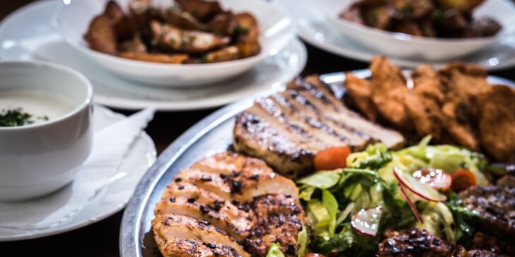 Masový talíř pro více osob: steaky, krkovička, míchaný salát a americké brambory